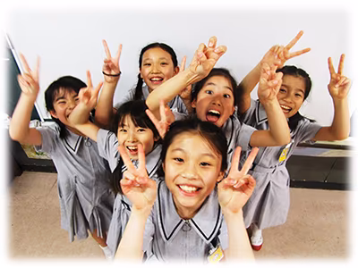 笑顔でカメラに向けてピースサインしている複数の女子生徒の写真